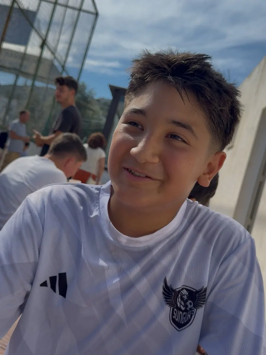 Beyaz forma ile gülümseyen Sungur Academy sporcusu